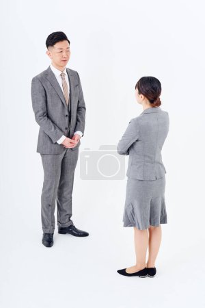 Photo for Man and woman in suits facing each other and white background - Royalty Free Image