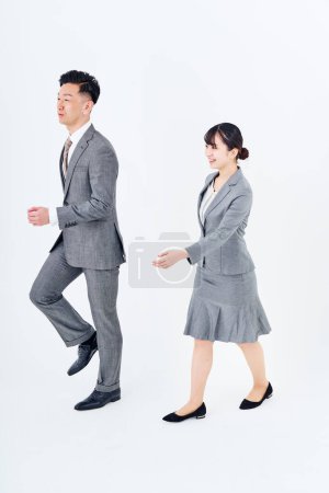 Photo for Man and woman in suits walking and white background - Royalty Free Image
