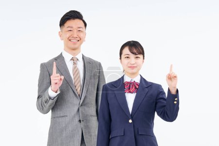 Photo for A man and a high school girl in a suit posing with their index finger up and white background - Royalty Free Image