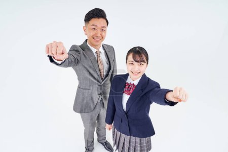 Téléchargez les photos : A man and a high school girl in a suit doing a guts pose and white background - en image libre de droit