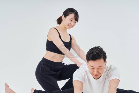 Téléchargez les photos : Man and woman doing stretching exercise and white background - en image libre de droit