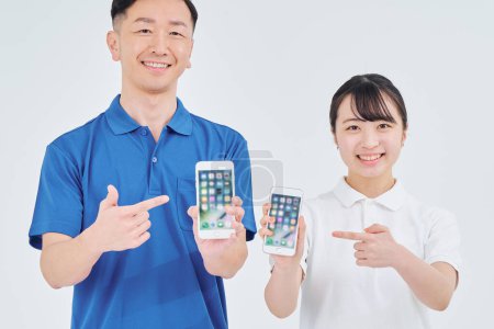 Téléchargez les photos : Homme et femme du personnel de l'entrepreneur avec smartphones et fond blanc - en image libre de droit