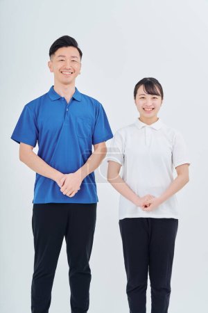 Photo pour Man and woman of contractor staff wearing polo shirts and white background - image libre de droit