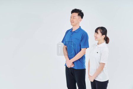 Foto de Man and woman of contractor staff wearing polo shirts and white background - Imagen libre de derechos
