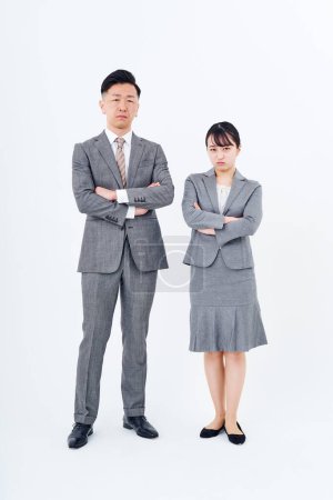 Foto de Hombre y mujer en trajes con expresiones estresadas y fondo blanco - Imagen libre de derechos