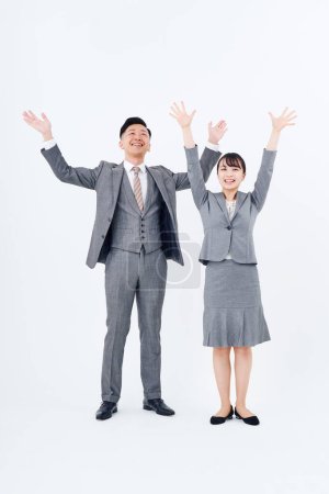 Téléchargez les photos : Man and woman in suits posing positively and white background - en image libre de droit