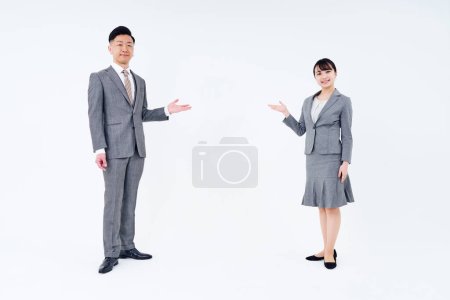 Téléchargez les photos : Homme et femme en costume posant pour l'orientation et le fond blanc - en image libre de droit