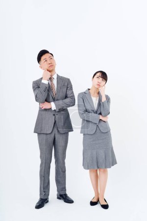 Téléchargez les photos : Un homme et une femme en costume qui posent une question et fond blanc - en image libre de droit