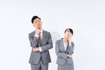 Téléchargez les photos : Un homme et une femme en costume qui posent une question et fond blanc - en image libre de droit