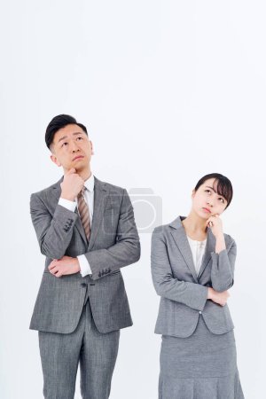 Photo for A man and woman in a suit who poses a question and white background - Royalty Free Image