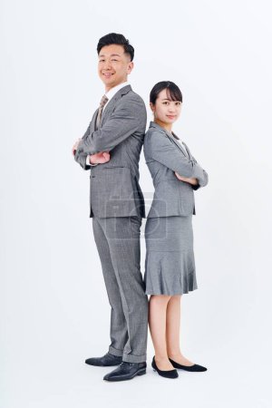 Foto de Man and woman in suits standing back to back and white background - Imagen libre de derechos