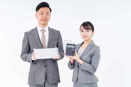 Foto de Man and woman in suits with keyboards and calculators and white background - Imagen libre de derechos
