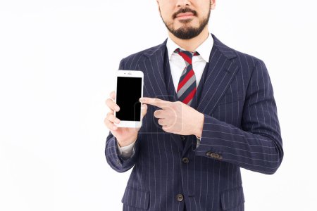 Téléchargez les photos : A man in a suit with a smartphone and white background - en image libre de droit