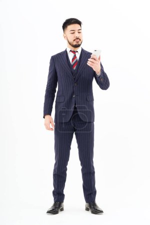 Téléchargez les photos : Un homme en costume opérant un smartphone et fond blanc - en image libre de droit
