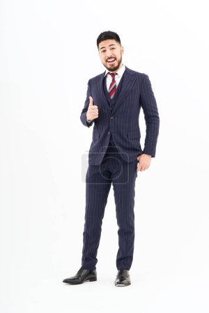Foto de A man in a suit doing a thumbs up pose and white background - Imagen libre de derechos