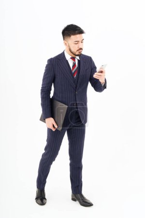 Foto de A man in a suit operating a smartphone and white background - Imagen libre de derechos