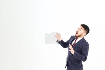 Foto de Un hombre con un traje con una expresión sorprendida y fondo blanco - Imagen libre de derechos