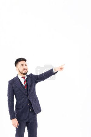 Foto de Un hombre con un traje apuntando hacia arriba y fondo blanco - Imagen libre de derechos