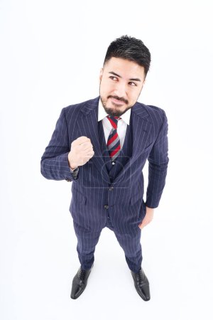 Téléchargez les photos : A man in a suit doing a guts pose and white background - en image libre de droit