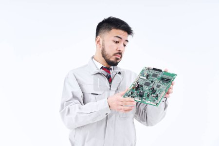 Téléchargez les photos : Un homme en vêtements de travail avec un tableau informatique et fond blanc - en image libre de droit