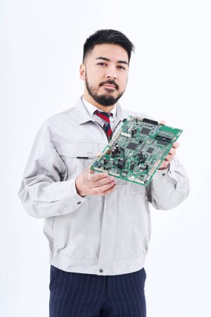 Foto de Un hombre en ropa de trabajo con una pizarra de ordenador y fondo blanco - Imagen libre de derechos