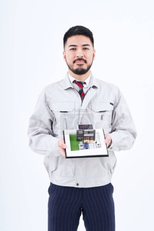 Téléchargez les photos : Un homme en vêtements de travail avec un modèle de maison et fond blanc - en image libre de droit