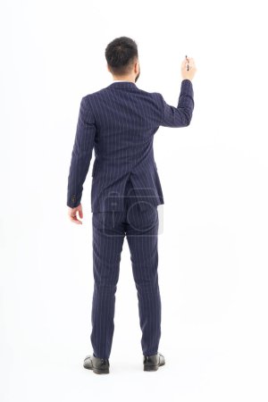 Téléchargez les photos : A man in a suit posing to write with a pen and white background - en image libre de droit