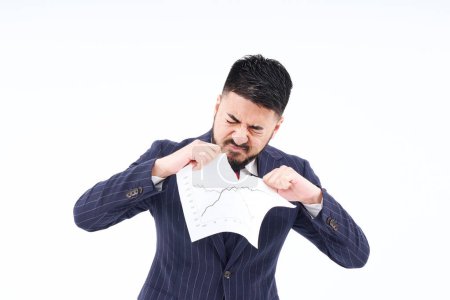 Téléchargez les photos : A man in a suit tearing up materials and white background - en image libre de droit