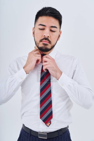 Téléchargez les photos : Homme d'affaires ajuster sa cravate et fond blanc - en image libre de droit