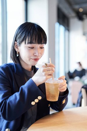 Téléchargez les photos : Une jeune femme se relaxant dans un café - en image libre de droit