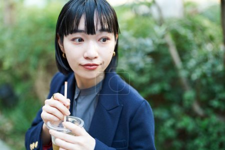 Téléchargez les photos : Jeune femme prenant un verre au coin de la rue - en image libre de droit