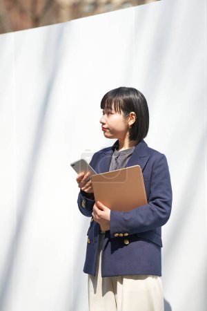 Foto de Una mujer sosteniendo un teléfono inteligente al aire libre - Imagen libre de derechos