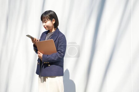 Téléchargez les photos : Une femme qui regarde son smartphone à l'extérieur - en image libre de droit