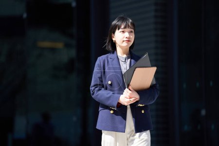 Téléchargez les photos : Portrait d'une jeune femme d'affaires debout à l'extérieur - en image libre de droit