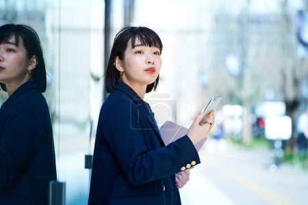 Téléchargez les photos : Une femme tenant un smartphone à l'extérieur - en image libre de droit