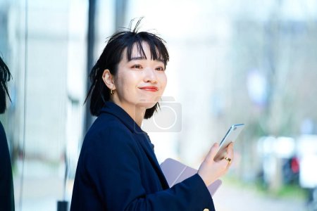 Téléchargez les photos : Une femme tenant un smartphone à l'extérieur - en image libre de droit
