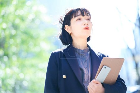 Téléchargez les photos : Une jeune femme qui regarde le ciel (femme d'affaires) - en image libre de droit