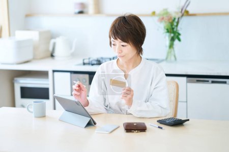Téléchargez les photos : Une femme tenant une carte et faisant fonctionner une tablette dans la pièce - en image libre de droit