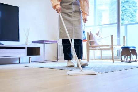 Photo for Asian woman cleaning the flooring in the room - Royalty Free Image