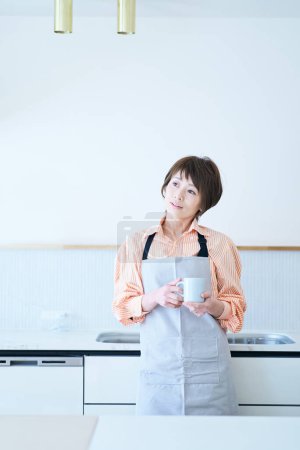 Photo for A woman in an apron with a stressed expression in the room - Royalty Free Image