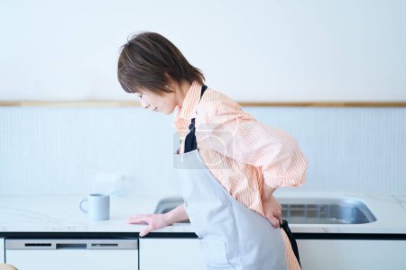 Photo for A woman in an apron with a stressed expression in the room - Royalty Free Image