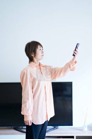 Photo for A woman holding a smartphone indoors - Royalty Free Image