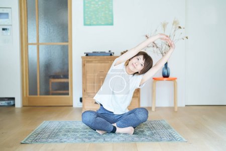 Photo for Asian woman stretching in the room - Royalty Free Image