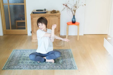 Foto de Asian woman stretching in the room - Imagen libre de derechos