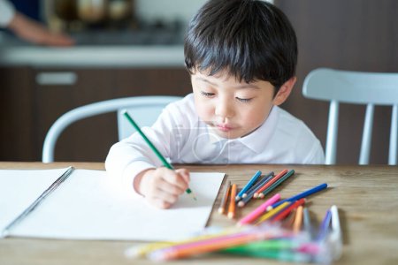 Foto de Un niño que está obsesionado con dibujar en la habitación - Imagen libre de derechos
