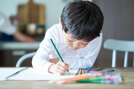 Foto de Un niño que está obsesionado con dibujar en la habitación - Imagen libre de derechos