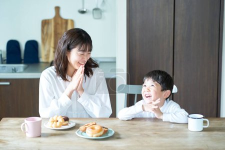 Téléchargez les photos : Mère et fils posent pour commencer à manger dans la chambre - en image libre de droit