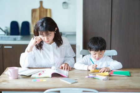 Photo for A mother studying in her room and a child playing next to her - Royalty Free Image