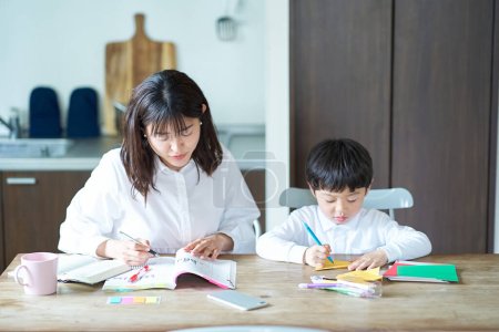 Photo for A mother studying in her room and a child playing next to her - Royalty Free Image
