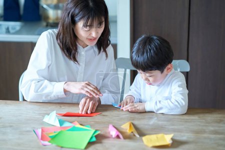 Foto de Padre e hijo jugando con origami en la habitación - Imagen libre de derechos